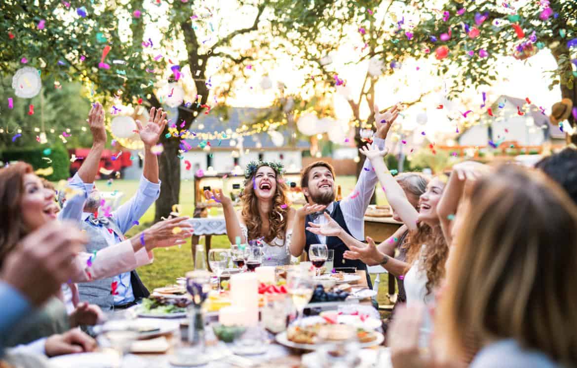 Friends theme song wedding entrance - bride and groom celebrating with guests in outdoor event