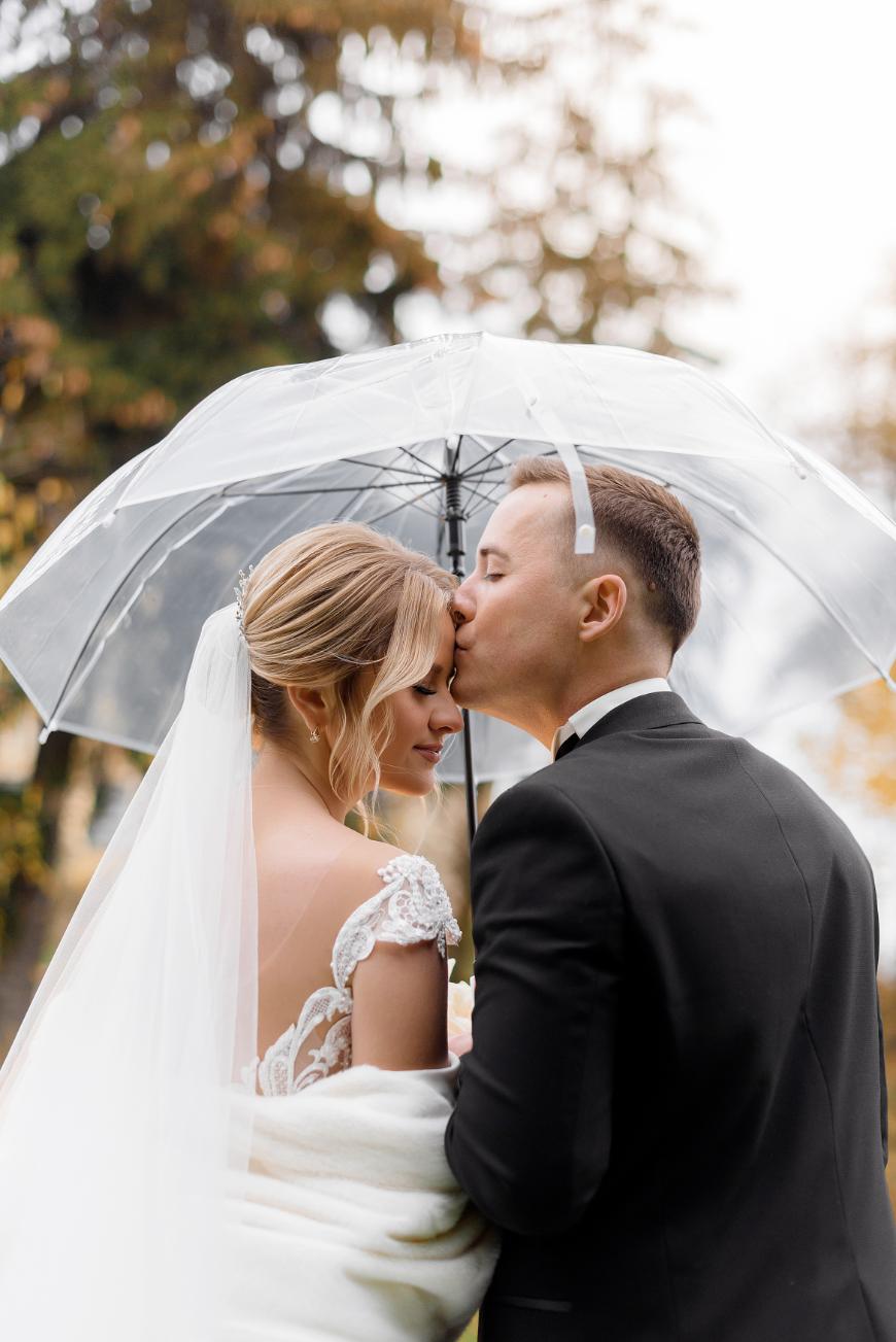 How-to-prepare-for-rain-on-wedding-day-bride-groom-kiss-on-the-forehead.