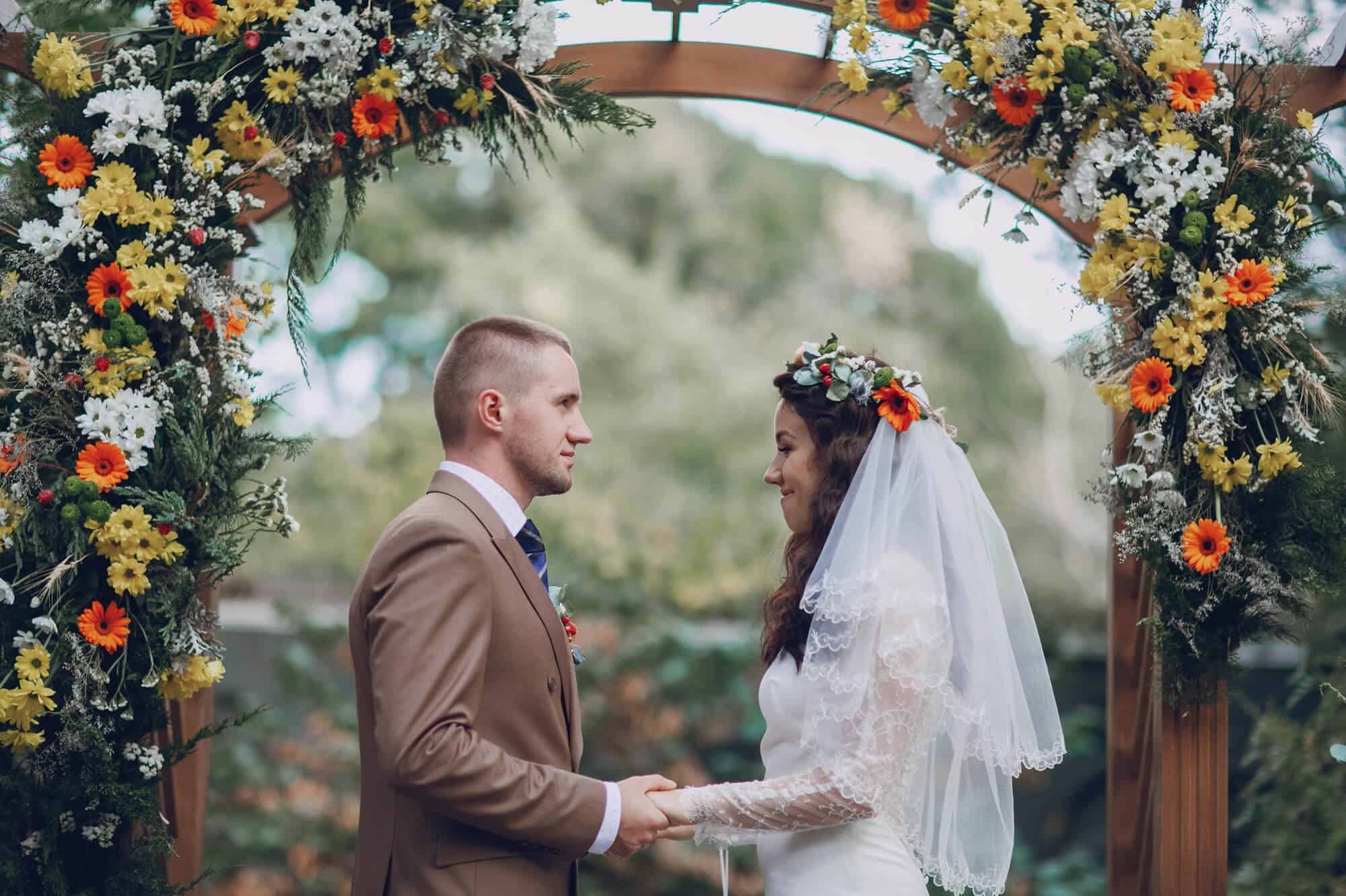 Summer-wedding-color-palette-for-the-bride-and-grooms-attire-Couple-holding-hands-bride-with-head-veil