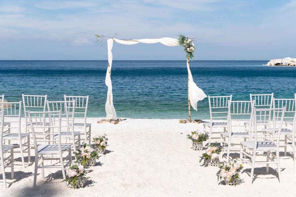 Micro wedding decor - empty beach, ceremony, flowers, sea