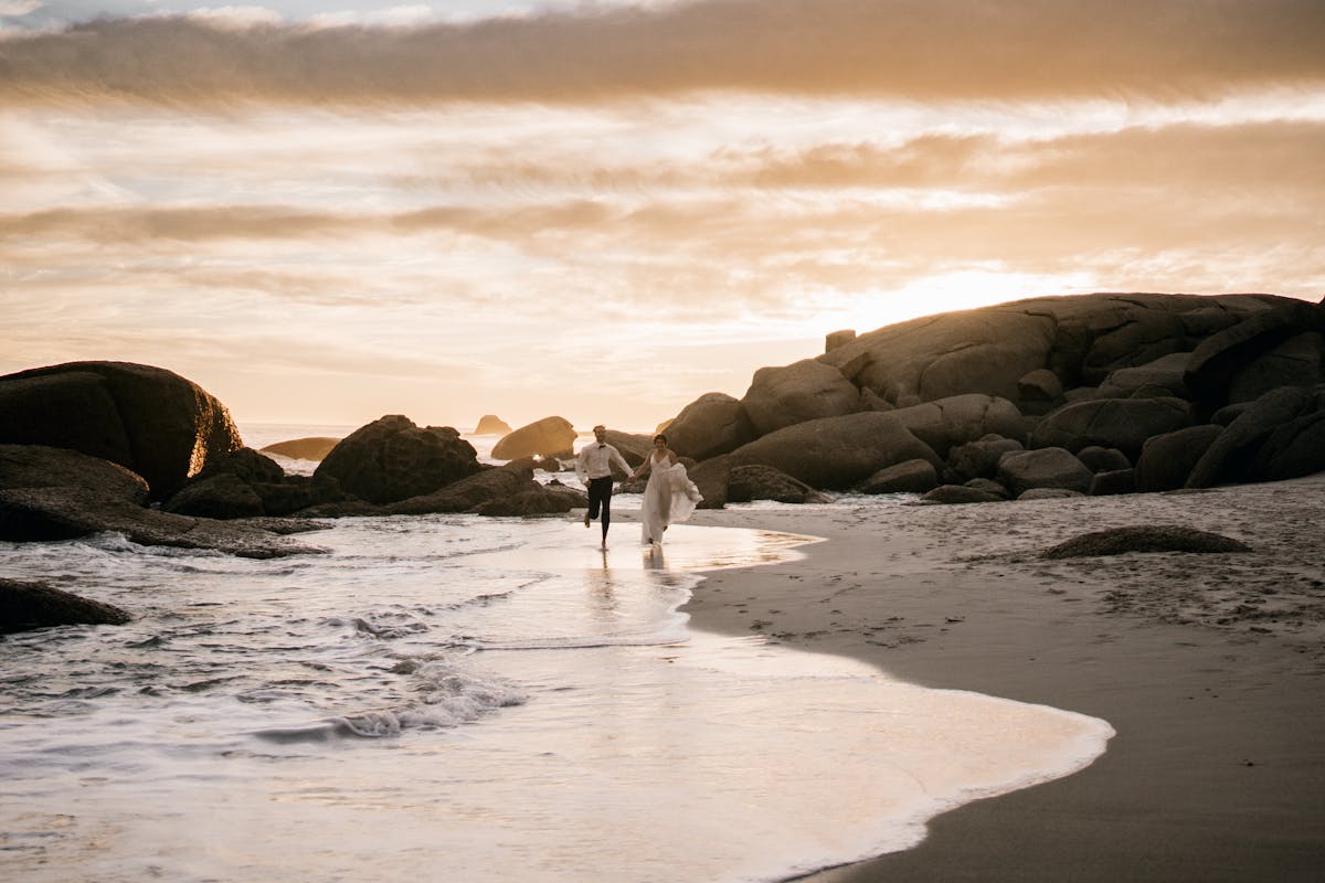 Tips and tricks that you should definitely include when planning an all white wedding decor_married couple running on the beach